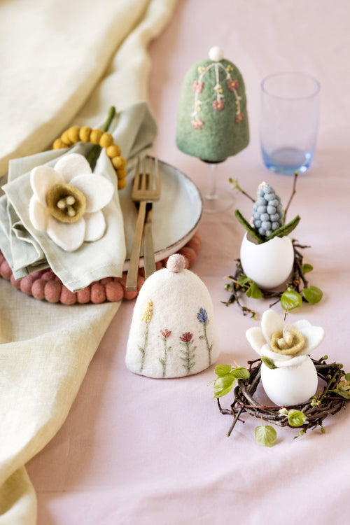 Eierwarmers en vilten paasdecoratie van Gry & Sif op een gedekte ontbijttafel